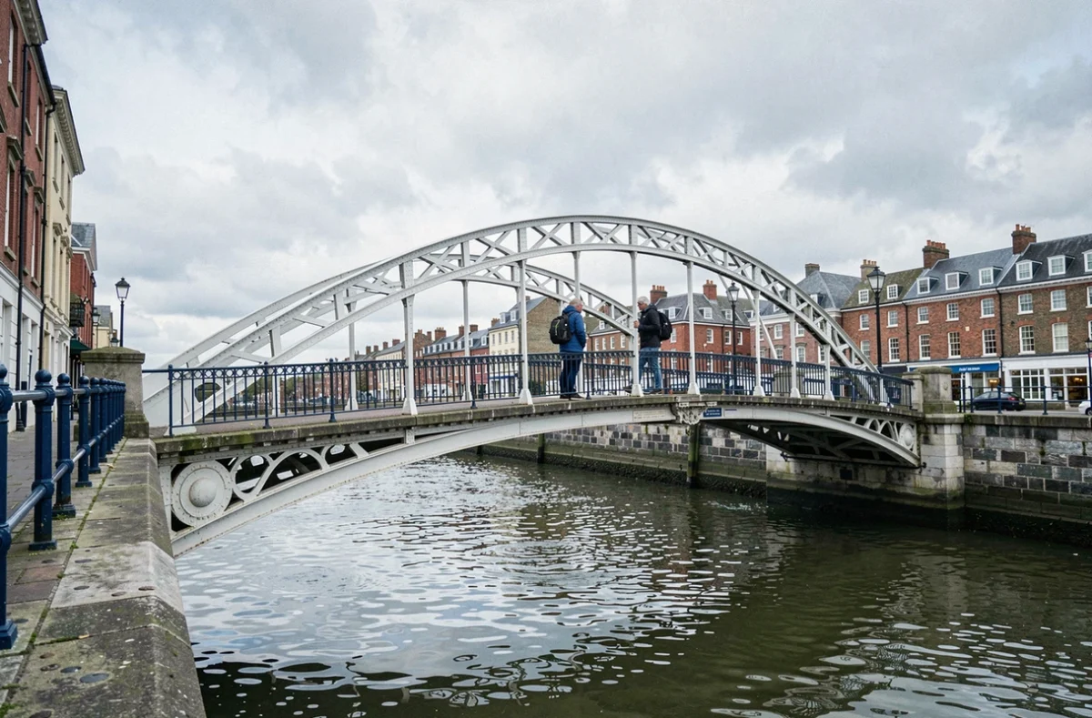 Pont Ha'penny Bridge à Dublin en avril avec peu de visiteurs, reflets de la rivière Liffey par temps nuageux